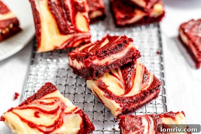 Red velvet cheesecake brownies arranged on a cooling rack after baking, displaying their vibrant colors.