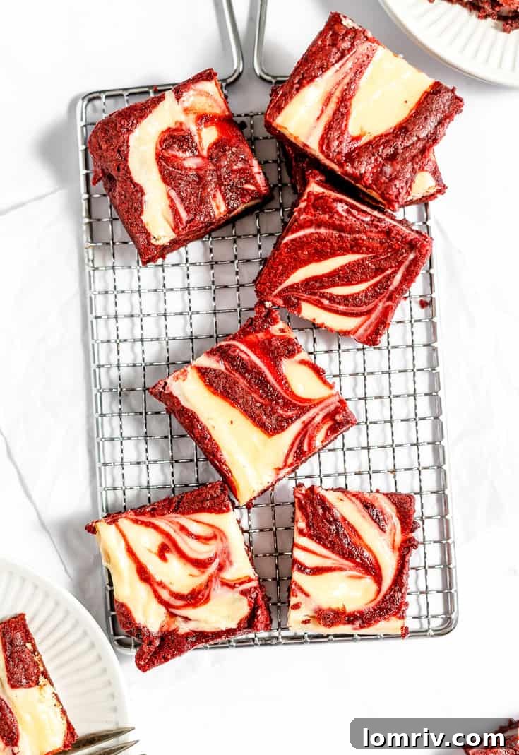 Freshly baked red velvet cheesecake brownies cooling on a wire rack, ready to be sliced and enjoyed.