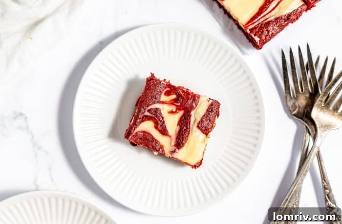 A single red velvet cheesecake brownie presented on a white plate, ready to be enjoyed.