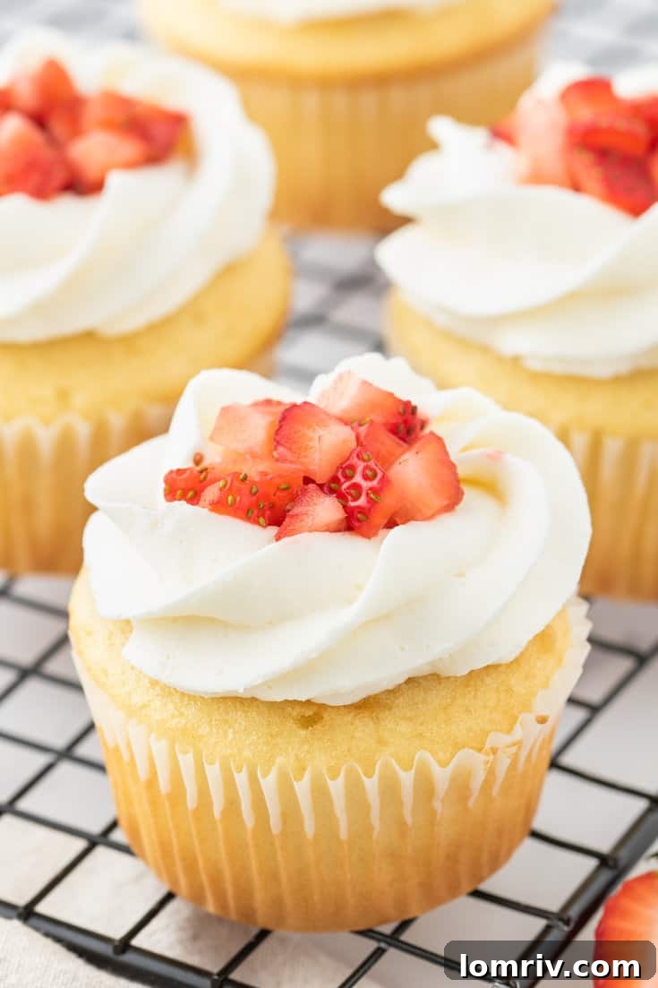 Strawberry shortcake cupcakes on a cooling rack. 