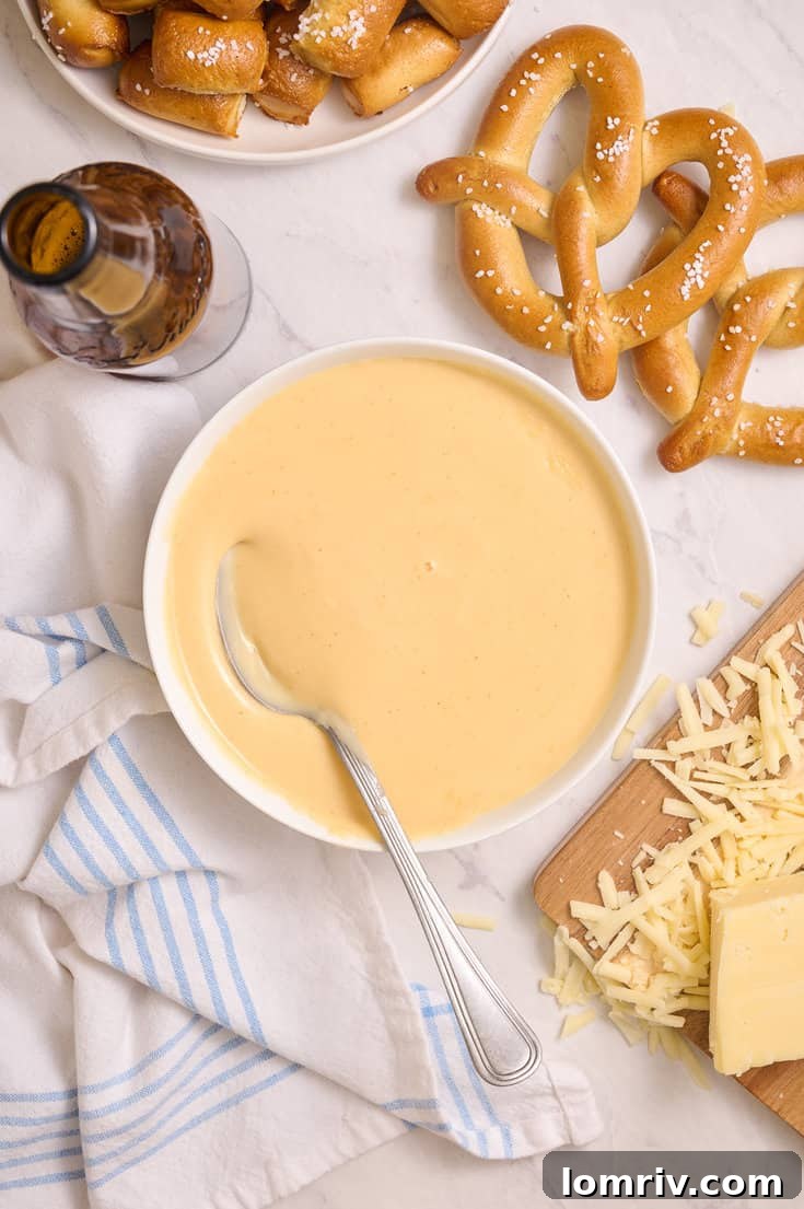 Beer cheddar cheese dip with a spoon in it. 