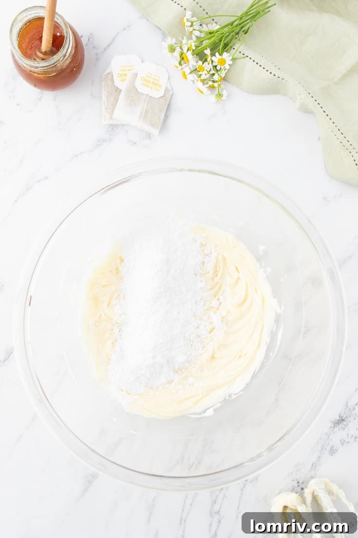 Adding powdered sugar to the buttercream.