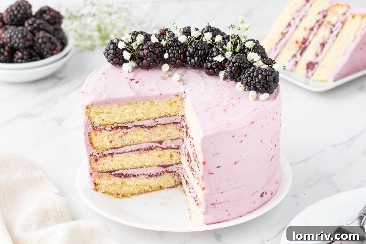 Blackberry layer cake with multiple slices removed, sitting on a serving board with fresh blackberries scattered around.