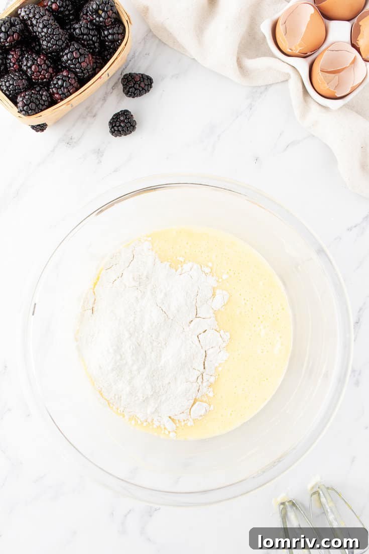 Mixing wet and dry ingredients together in a large bowl with an electric mixer until just combined.
