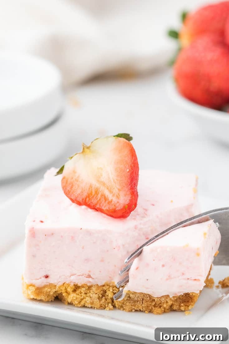 Strawberry cheesecake bar with a bite taken out of it.