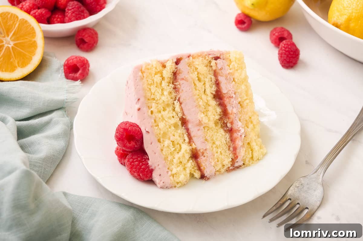 Another enticing close-up view of a perfectly cut slice of Lemon Raspberry Layer Cake, emphasizing its appealing vibrant layers and promising deliciousness, ideal for a dessert table.