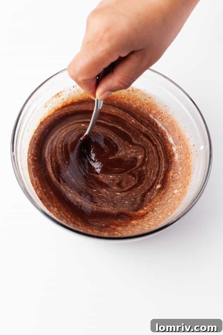 Whisking the chocolate ganache until smooth and glossy