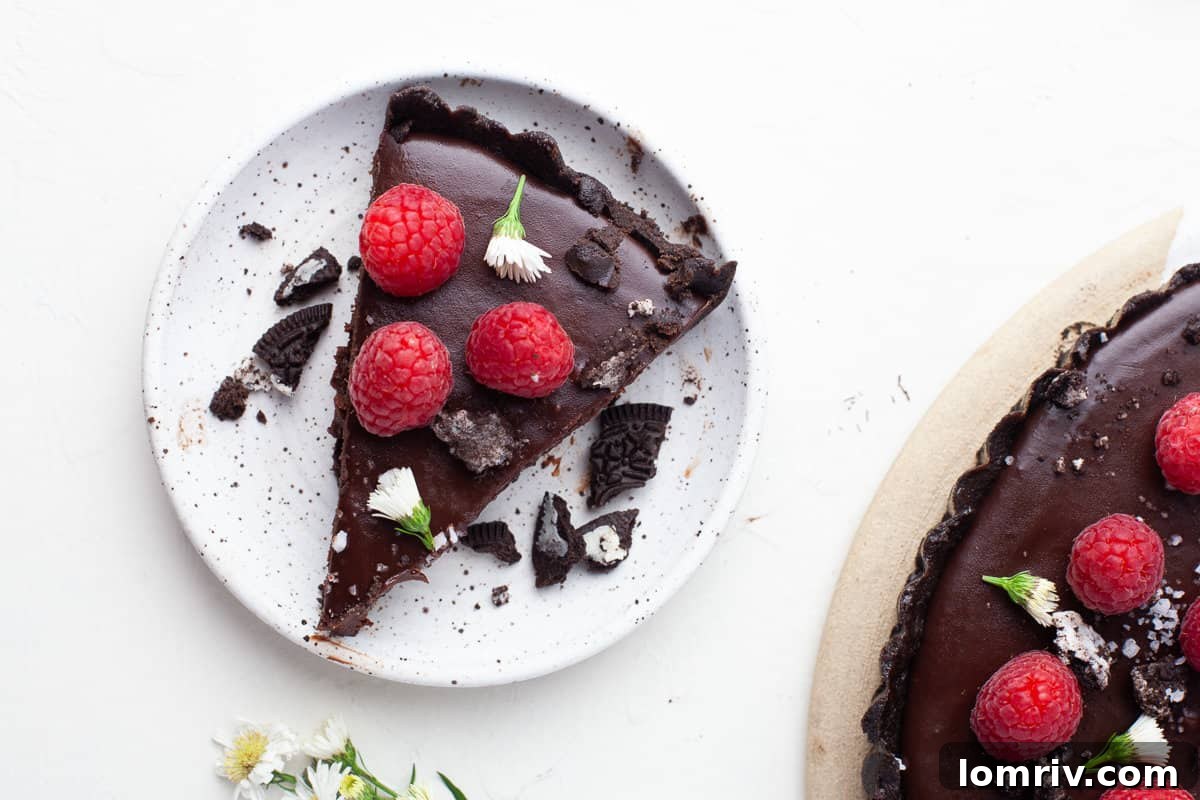 A whole no-bake chocolate tart with raspberries and sea salt, seen from a high angle