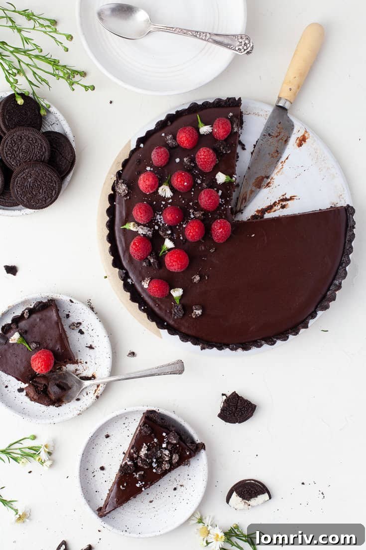 Close-up of a sliced no-bake chocolate tart showing the thick ganache filling and Oreo crust