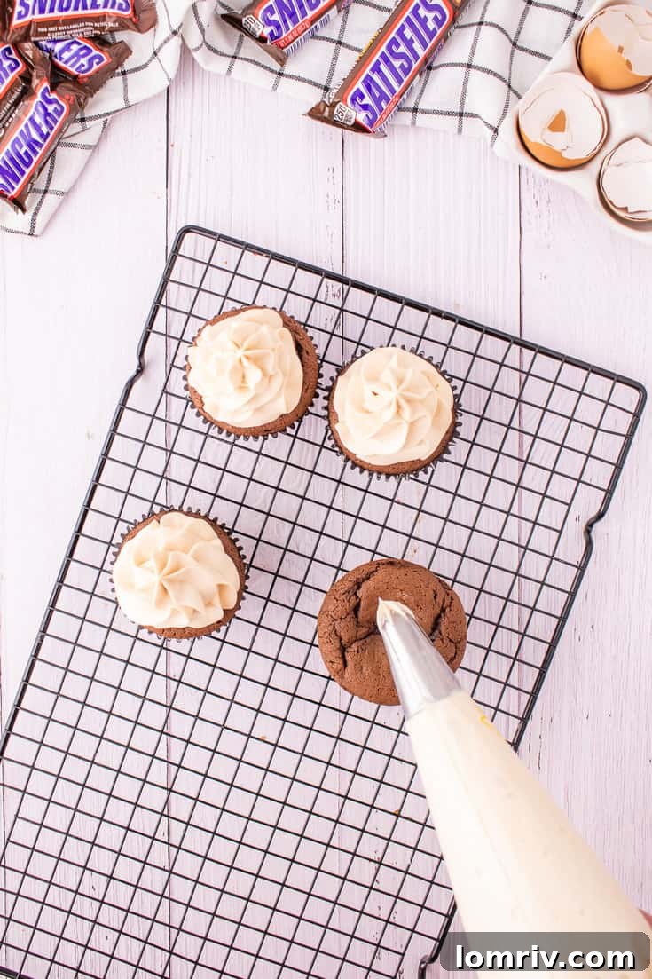 Piping the frosting onto the cupcakes.