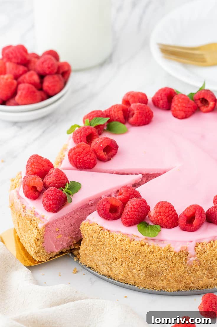 Decadent Raspberry Cheesecake Slice with Fresh Berries and Mint
