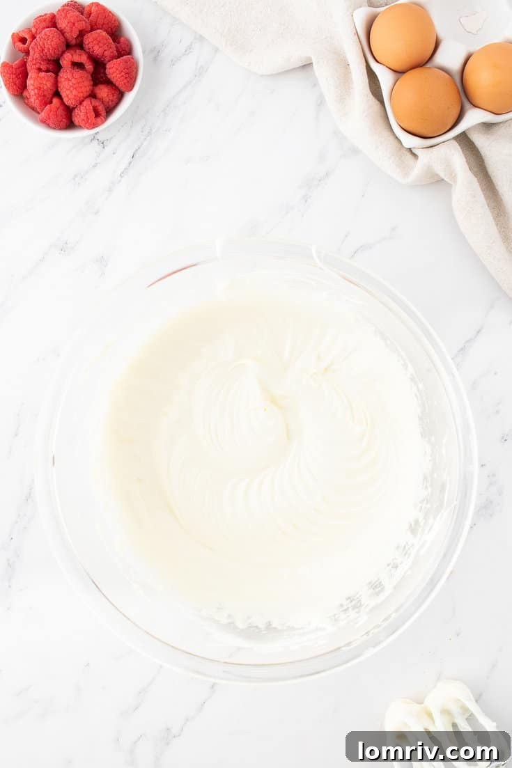 Slowly adding granulated sugar to the cream cheese mixture