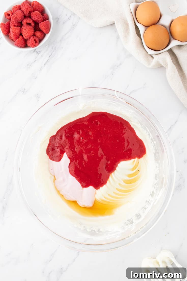 Mixing raspberry puree, Greek yogurt, and vanilla extract into the batter