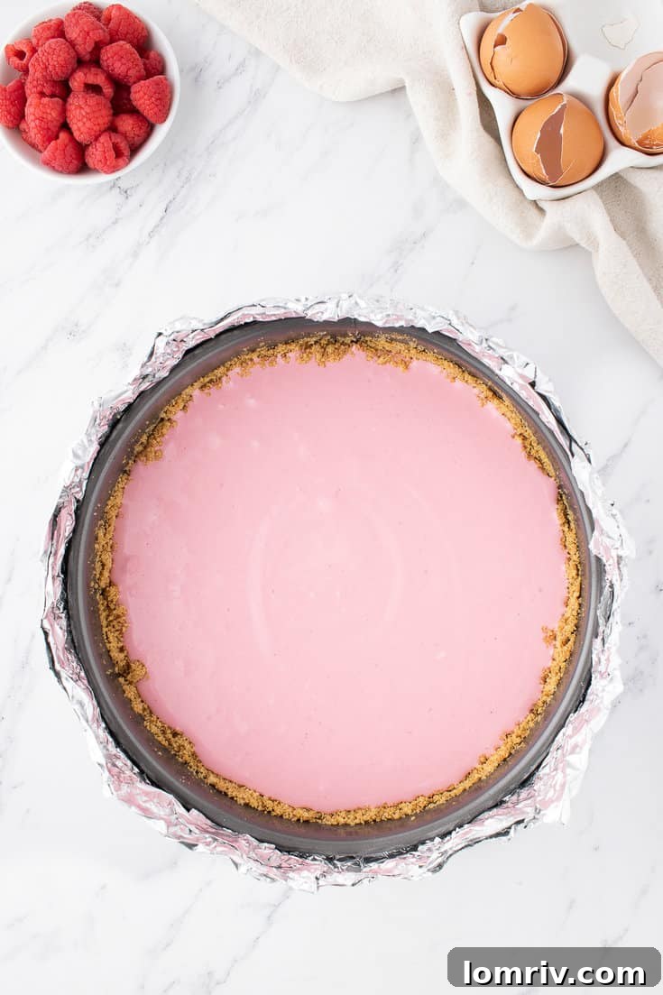 Smooth cheesecake batter poured into the pre-baked graham cracker crust