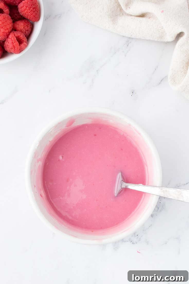 Mixing raspberry puree and heavy cream into the melted white chocolate