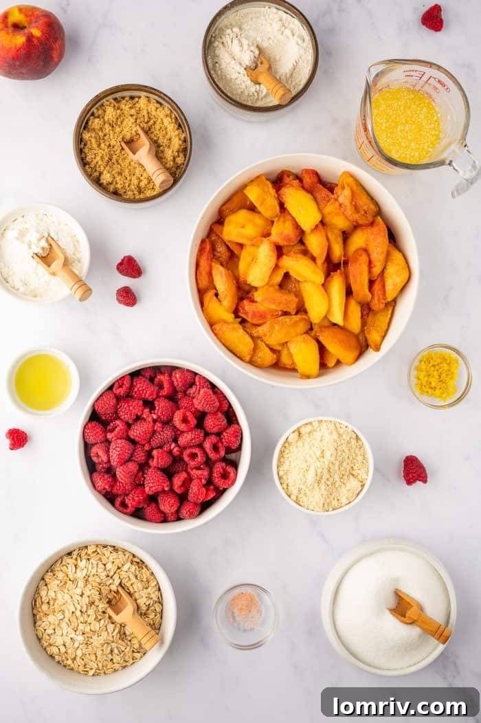 All the fresh ingredients laid out for making peach raspberry crumble: peaches, raspberries, oats, flours, sugars, butter, and lemon.