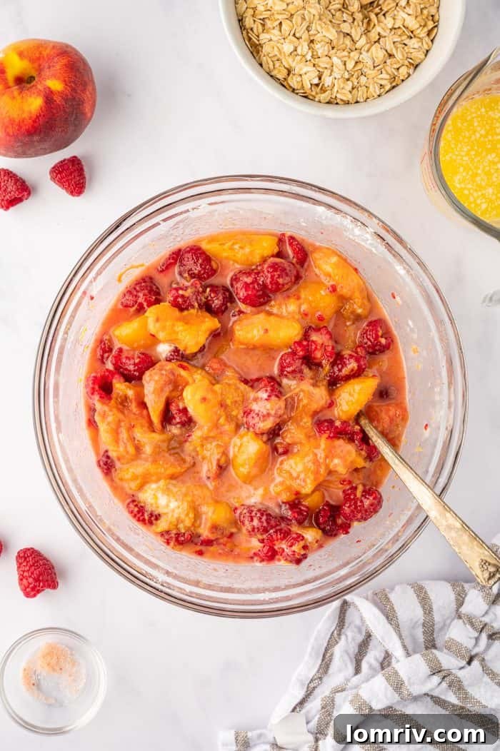 The mixed peach and raspberry filling with cornstarch, perfectly coated and ready for the baking dish.