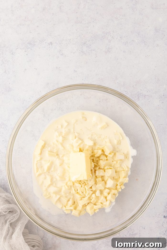 White chocolate and butter combined in a mixing bowl, ready for the hot cream.