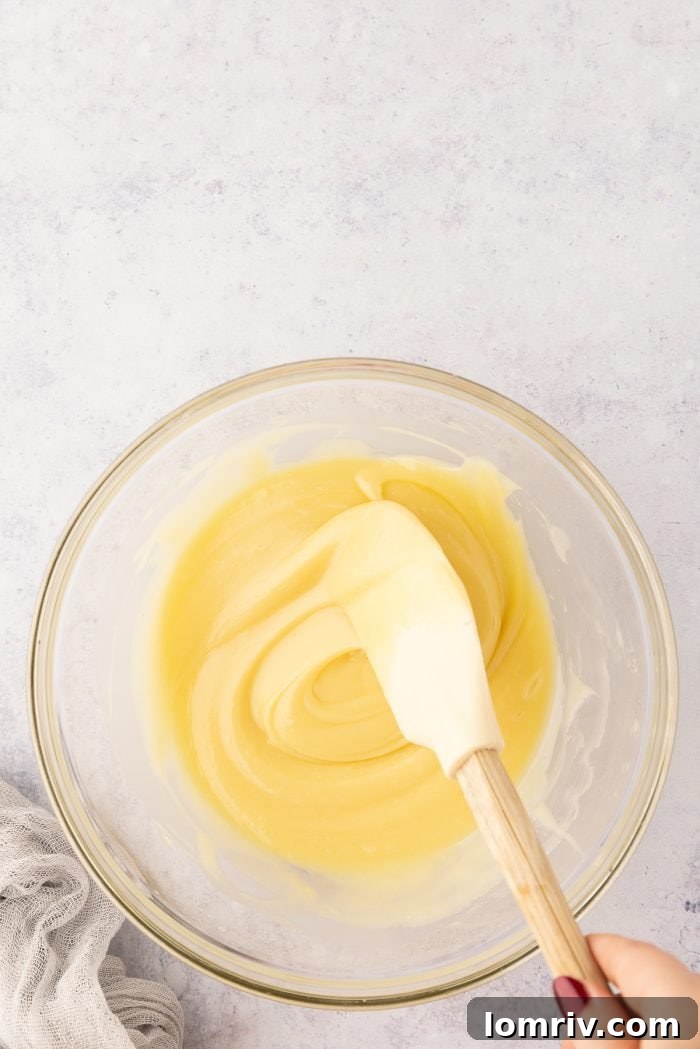 Smooth, melted white chocolate ganache in a glass bowl.