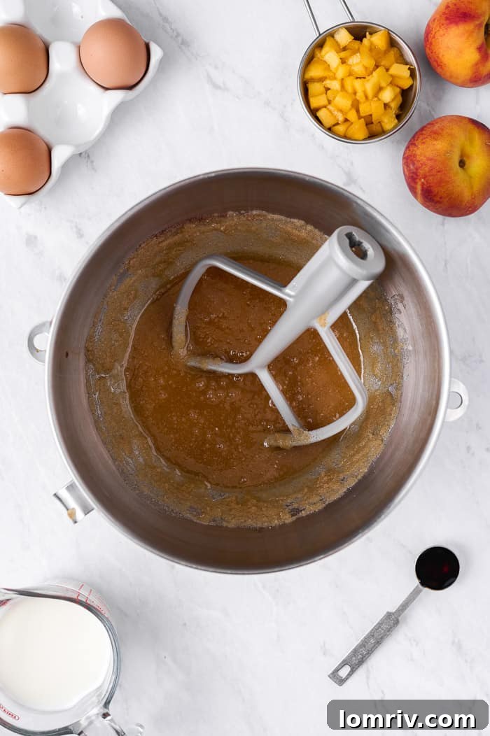 Mixing browned butter, sugar, eggs, and vanilla extract in an electric mixer