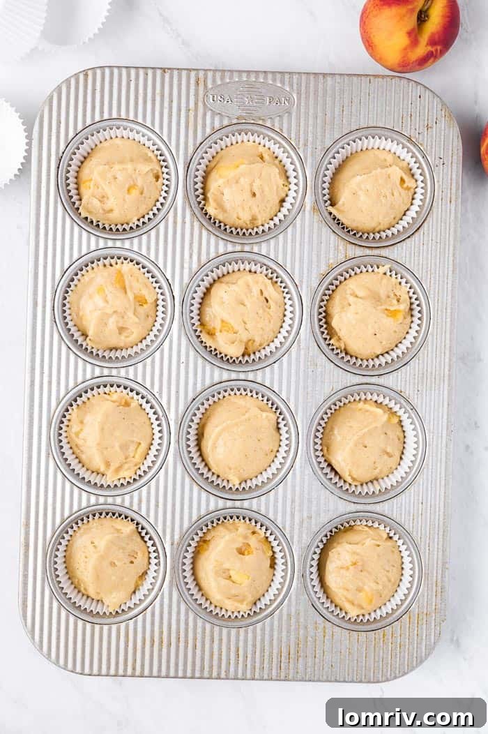 Cupcake batter divided into paper liners in a muffin tin