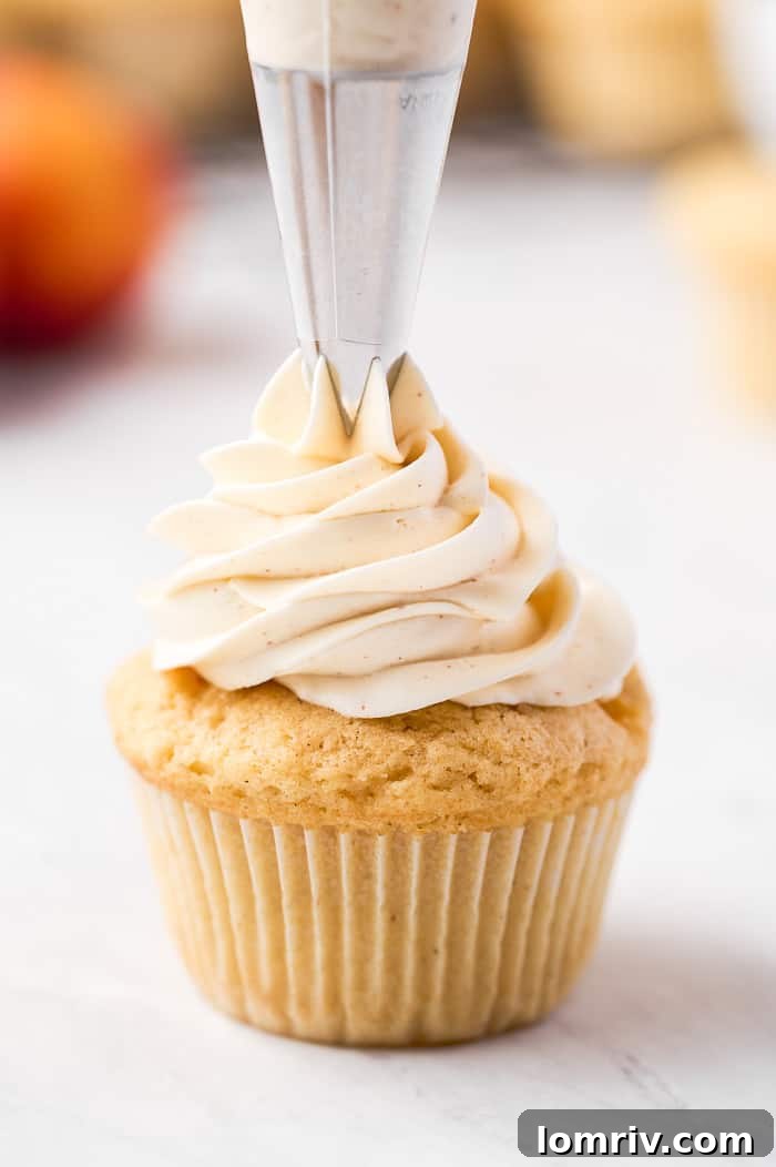 Finished brown butter peach cupcake with intricate frosting swirl