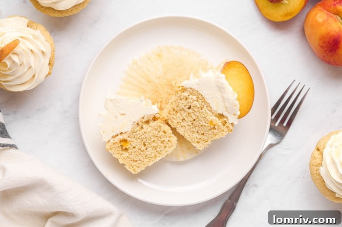 Several frosted brown butter peach cupcakes displayed on a wooden surface