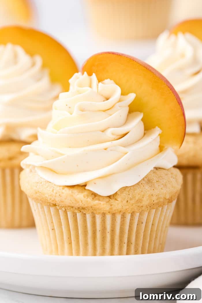 A trio of perfectly baked brown butter peach cupcakes, ready for frosting