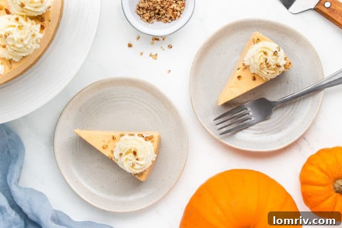 Two elegant plates each holding a slice of the pumpkin cheesecake, artfully arranged with autumn pumpkins in the background as festive decoration.
