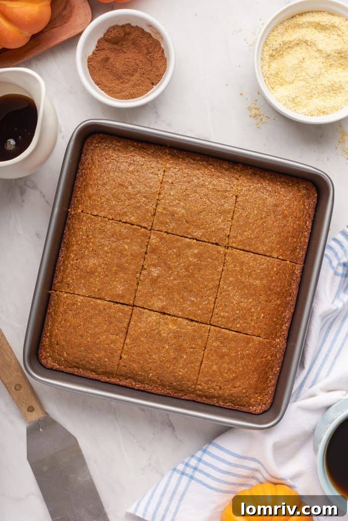 A baking tray with baked pumpkin cornbread that has been sliced.