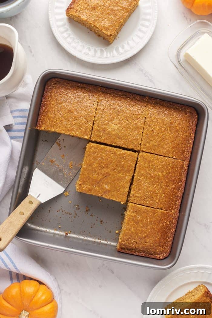 A baking pan filled with slices of pumpkin cornbread with a few slices removed.