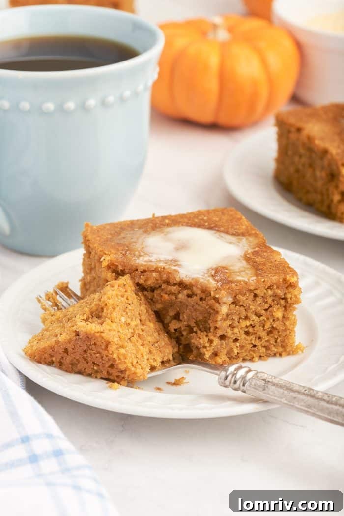 A slice of pumpkin cornbread with a fork slicing through it.