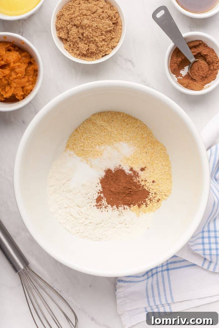 A bowl filled with ingredients to make pumpkin cornbread.