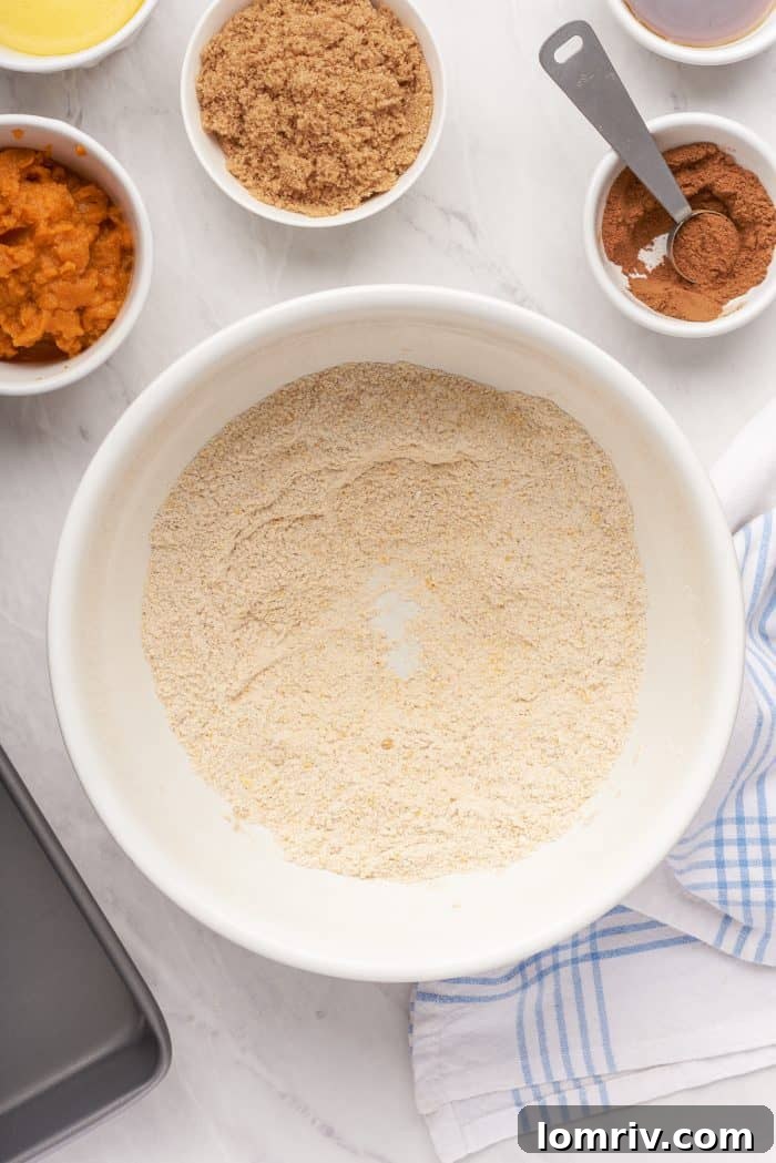 A bowl with flour, cornmeal, and pumpkin spice mixed together.