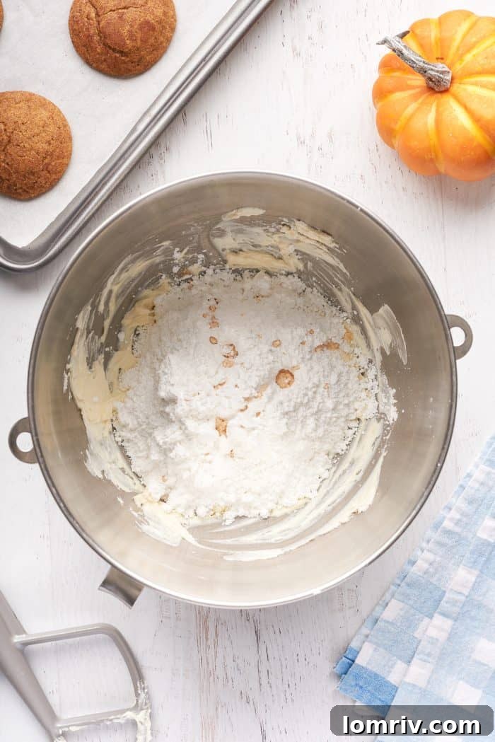 Cream cheese mixed with icing sugar in a mixing bowl.