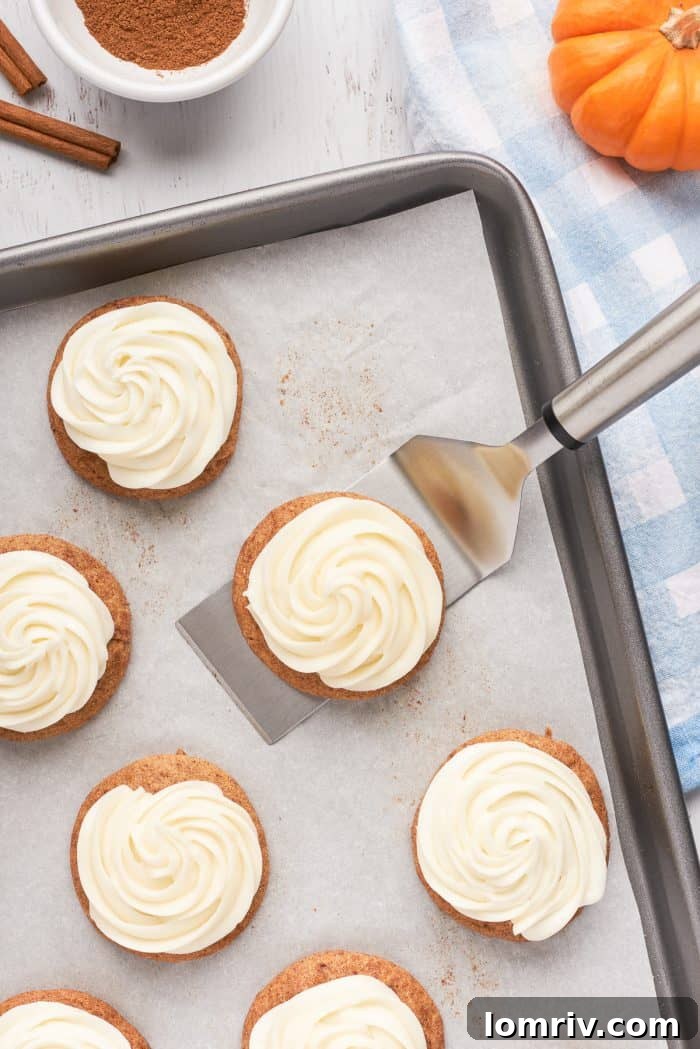 A baking tray with frosted pumpkin snickerdoodles.
