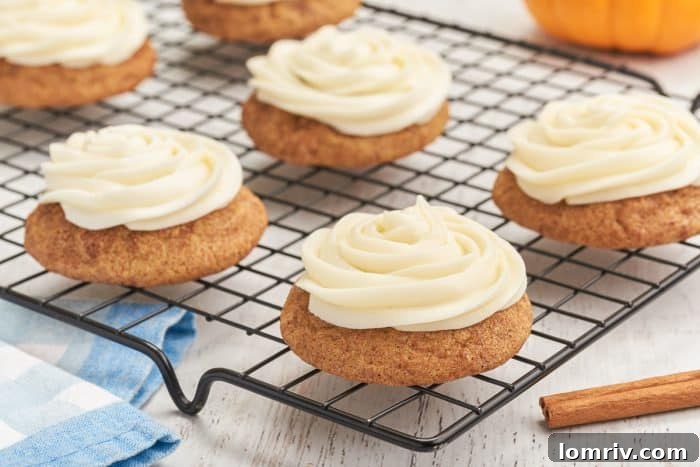 A cooling rack with frosted pumpkin snickerdoodles.
