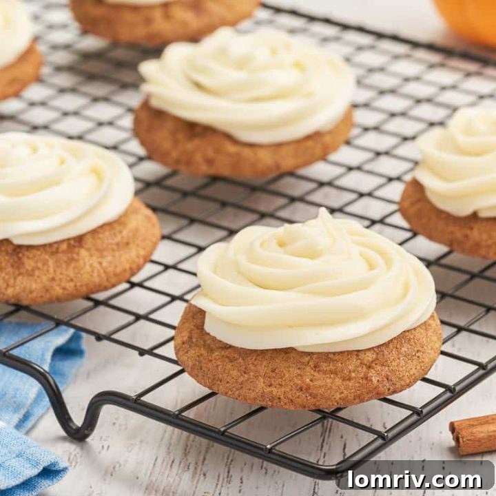A cooling rack with frosted pumpkin snickerdoodles.