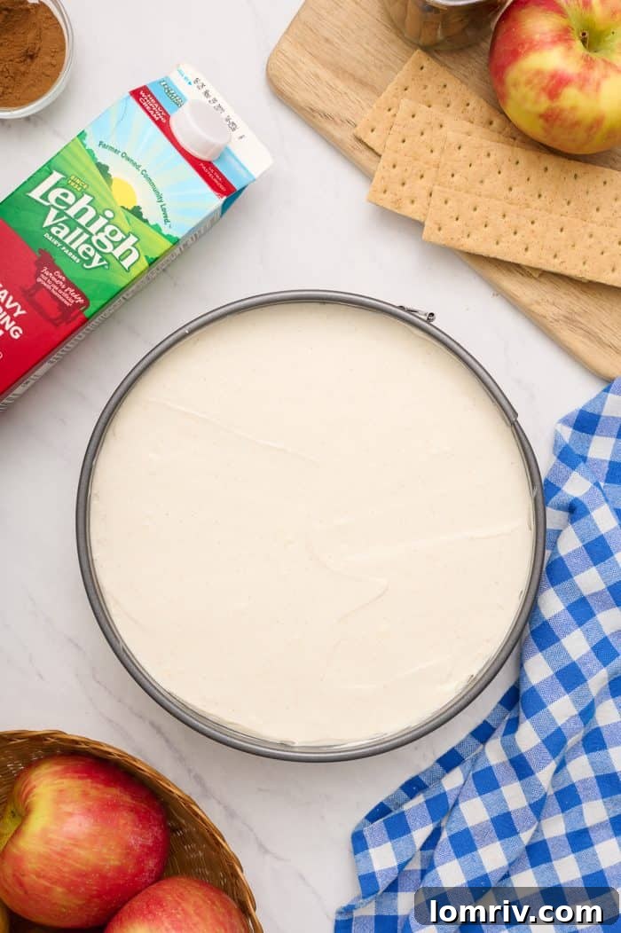 A springform pan filled with the perfectly smooth and even cream cheese filling, chilling to set.