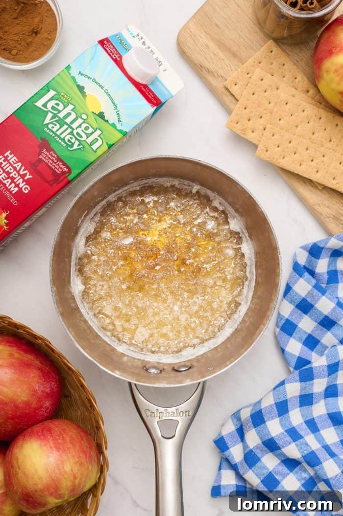 A saucepan containing brown sugar and water, heating on a stovetop, capturing the beginning stage of caramel making.