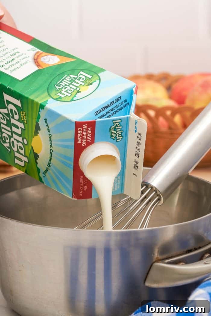 Lehigh Valley heavy cream being carefully poured into a hot saucepan of amber-colored sugar mixture, essential for creating creamy caramel.