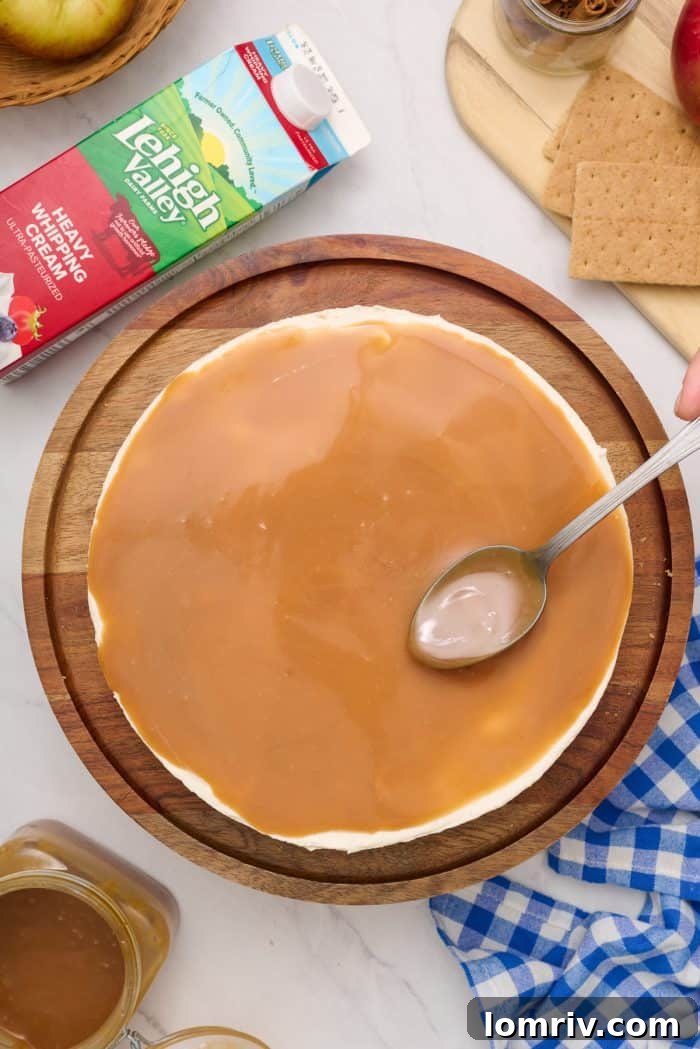 An overview of the entire no bake apple caramel cheesecake, with its top fully covered in a glistening layer of caramel.