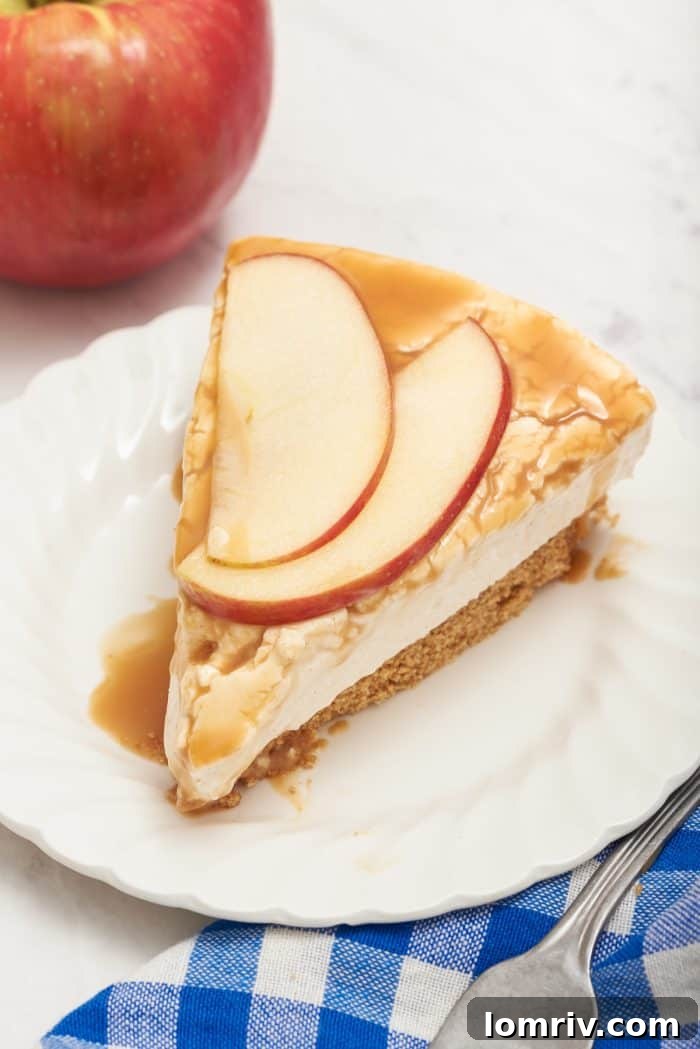 A close-up shot of the finished no bake caramel apple cheesecake on a white plate, showcasing its rich caramel topping.