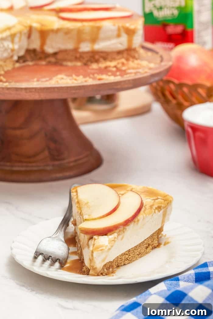 A beautifully presented slice of apple caramel cheesecake on a white plate, ready to be enjoyed with a fork.