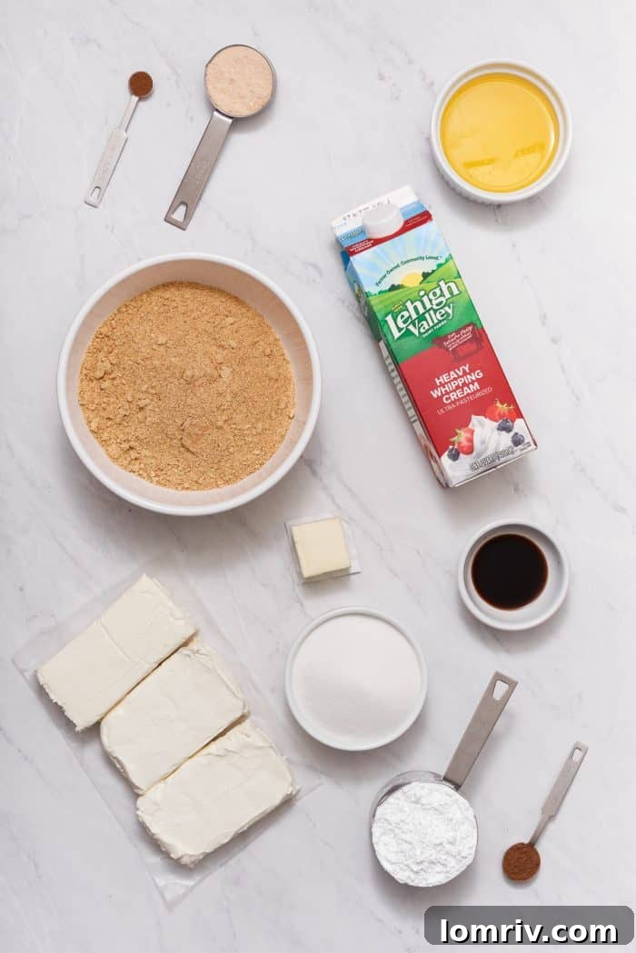 All the fresh ingredients laid out for preparing a no bake caramel apple cheesecake, including graham cracker crumbs, cream cheese, apples, and heavy cream.