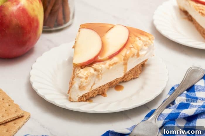 A close-up shot of a single slice of apple caramel cheesecake on a pristine white plate, showcasing its layers.