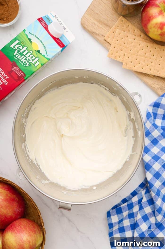 A bowl containing softened cream cheese, ready to be beaten for the cheesecake filling.