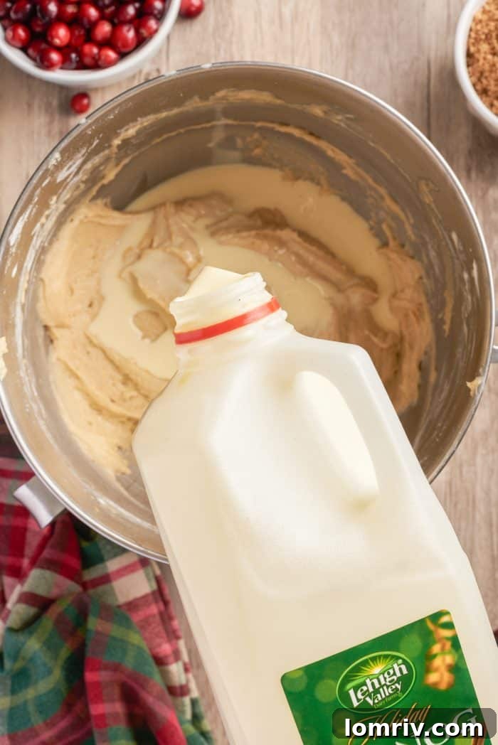 Lehigh Valley eggnog being poured into the smooth, creamy cake batter in a mixing bowl, adding its signature holiday flavor.