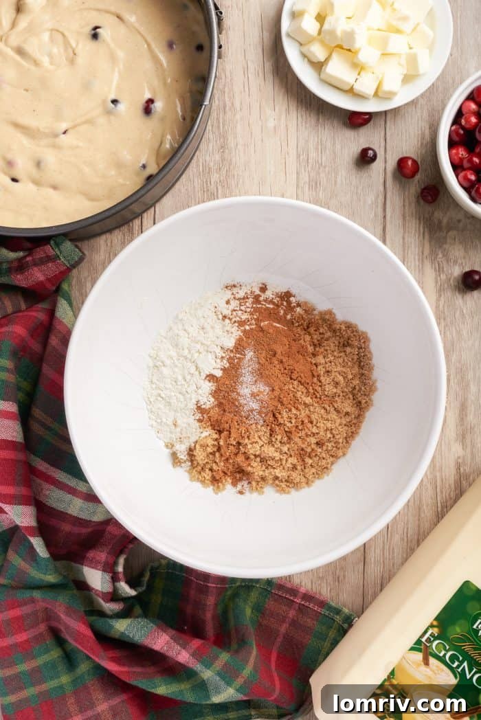 A white bowl showcasing the dry ingredients for the cinnamon crumble topping – flour, sugar, cinnamon, and nutmeg – before butter is added.
