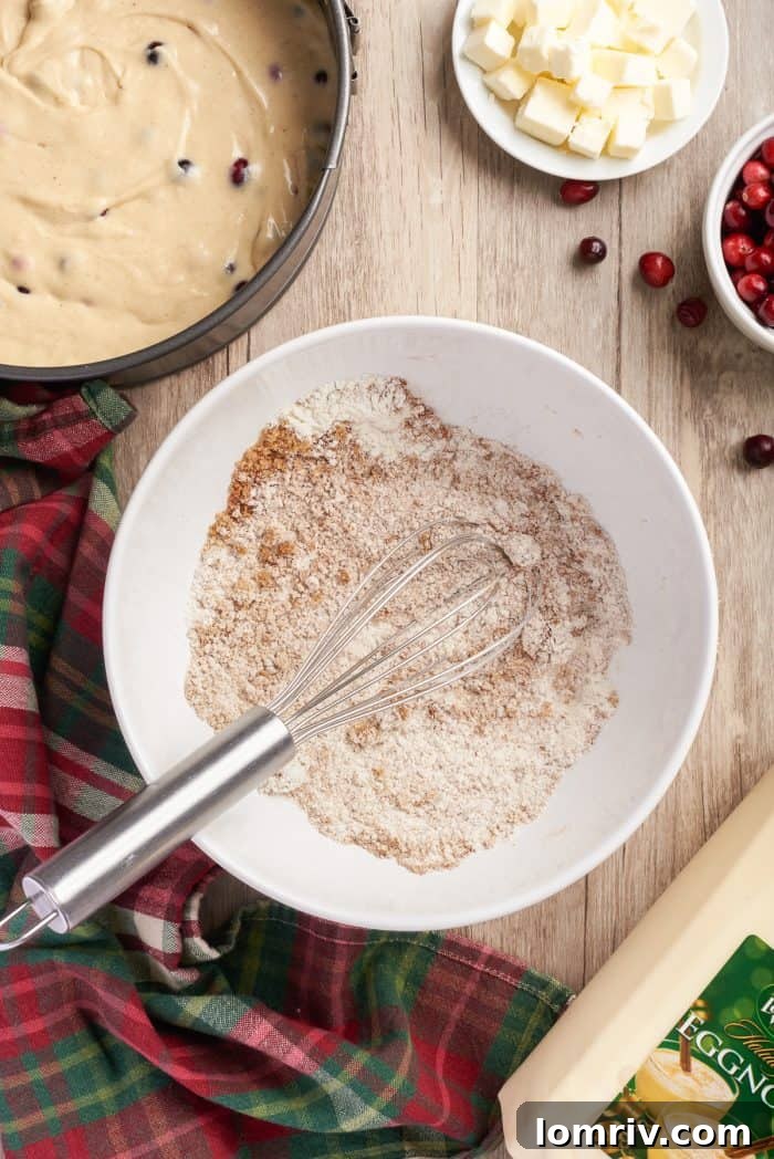 The mixed dry ingredients for the streusel topping (flour, sugar, and spices) in a white bowl, poised for the addition of butter.